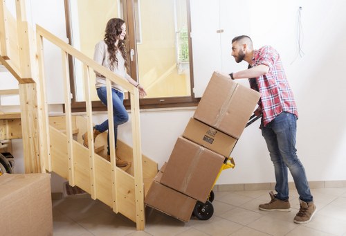 Professional movers carrying items through a residential property in Downham